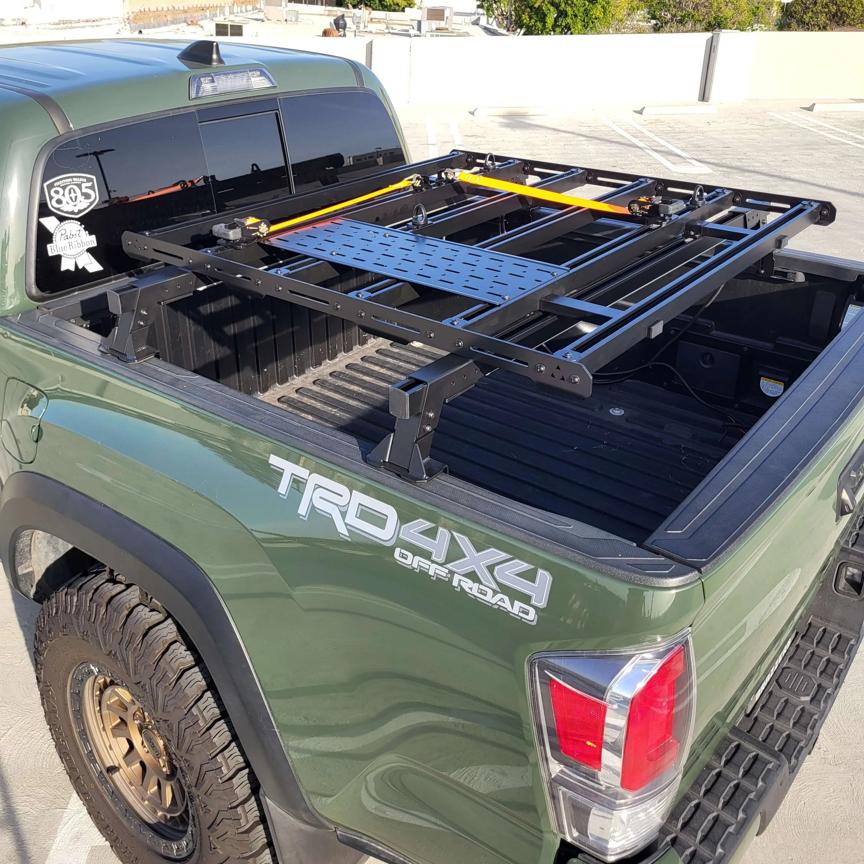 Green truck with a platform rack and 'TRD 4X4 Off Road' branding.