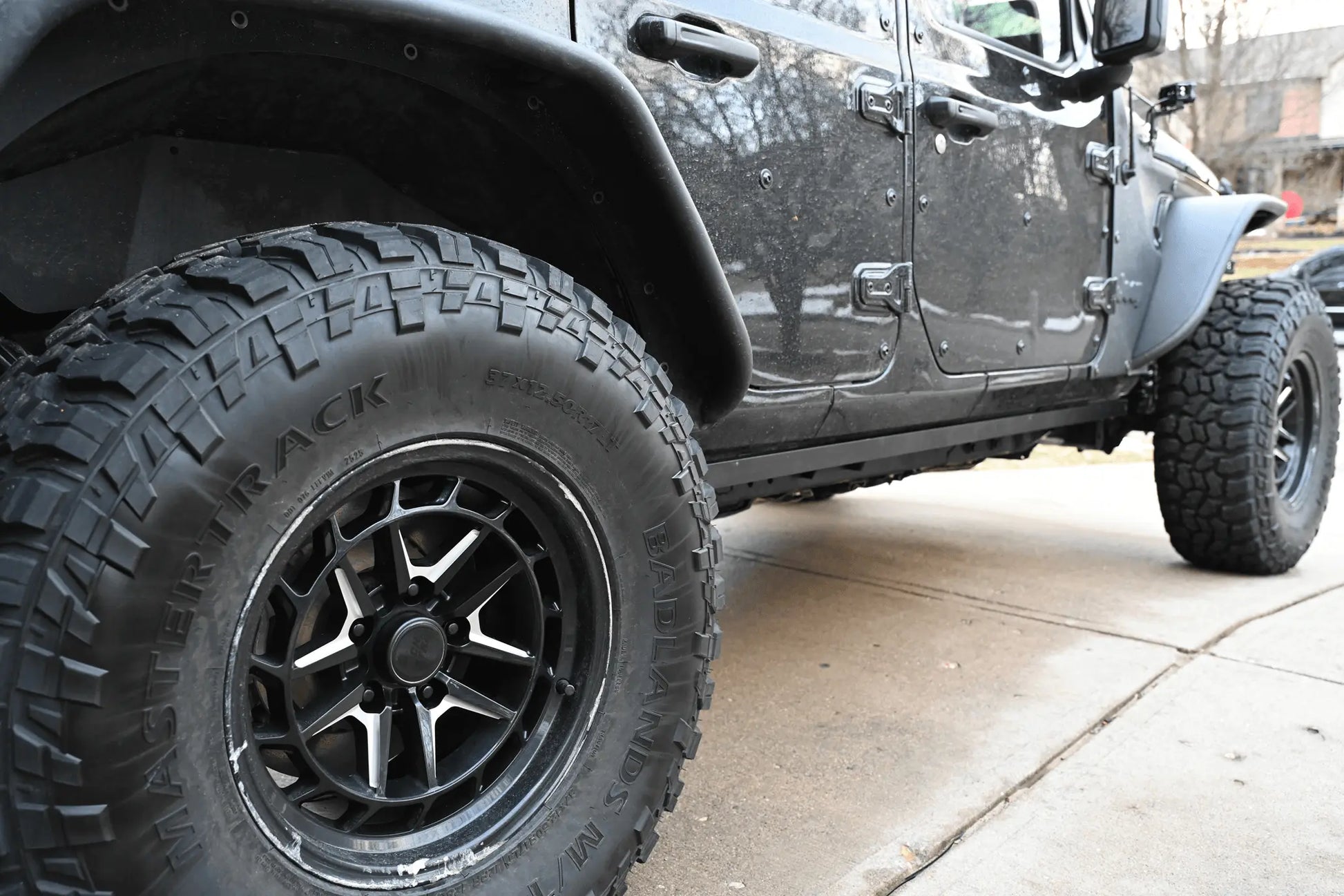 Black Jeep Wrangler JL with pinch weld covers installed, rear side view
